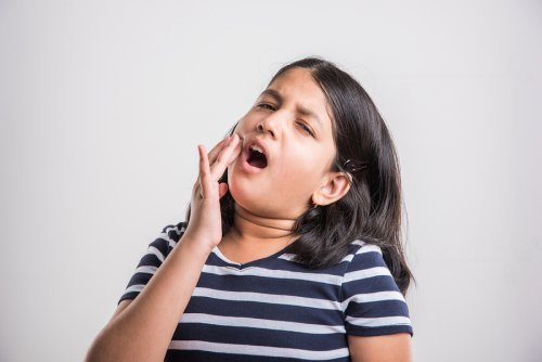 A girl in pain holding her cheek