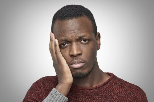 A man in pain holding his cheek