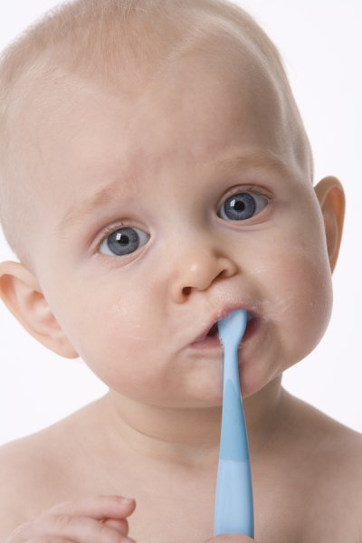 Little baby boy holding toothbrush in his mouth