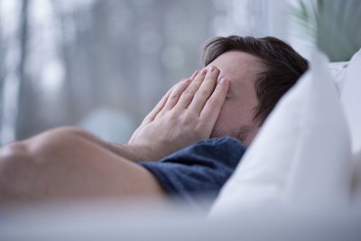 A man covering his face with hands and sleeping