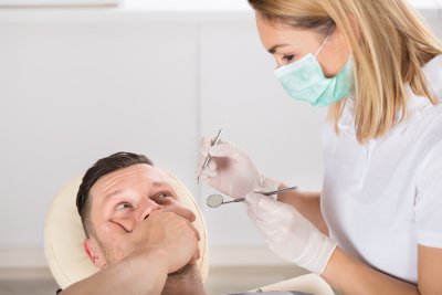 Lady dentist checking the man at the dentist clinic
