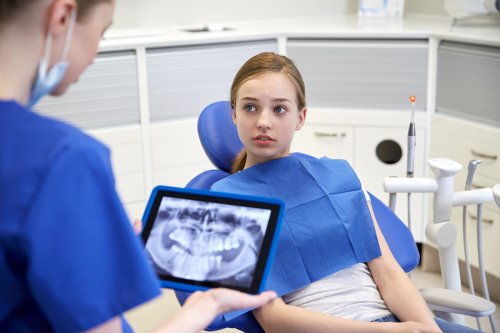 Dentist checking the X ray of a young girl